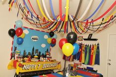 a birthday party with balloons and streamers hanging from the ceiling