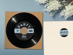 an old vinyl record next to a note and envelope with the word party on it