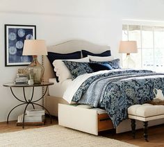 a bedroom with white walls and blue bedding