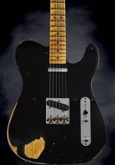 an electric guitar with black and gold paint on it