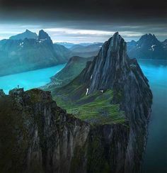 an aerial view of the mountains and lakes in norway, with blue water at the bottom