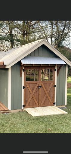 a small shed with two doors on the front and one door open to let in light