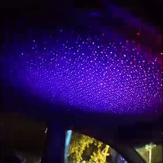 the interior of a car is lit up with purple and blue lights in the dark