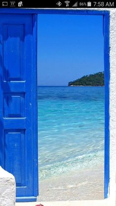 an open blue door leading to the ocean