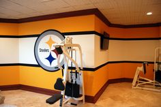 an exercise room with pittsburgh football logo painted on the wall