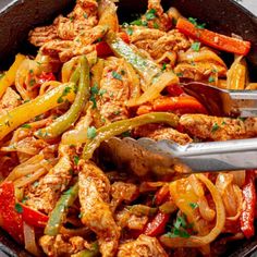 a skillet filled with chicken and peppers next to tortilla chips on a table