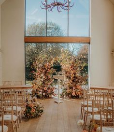 an indoor wedding venue set up with chairs and flowers