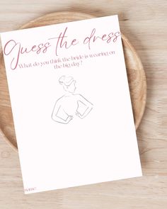 a piece of paper with the words guess the dress on it next to a wooden plate