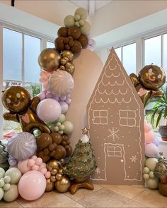 a gingerbread house surrounded by balloons and other decorations