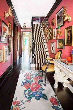 the hallway is decorated in pink, black and white with pictures on the wall above it