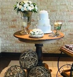 a table topped with three cakes and vases filled with flowers