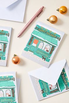 three christmas cards with envelopes on top of them and gold ornaments around the edges