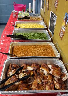 several trays of food are lined up on a table