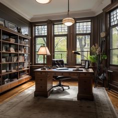 a home office with large windows and lots of bookshelves