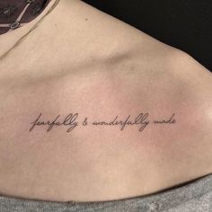 a woman with a tattoo on her chest saying, happily is wonderfully made in cursive writing