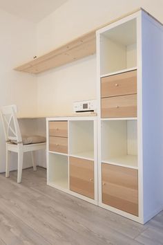 an empty room with white and wood furniture