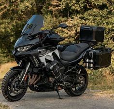 the motorcycle is parked on the side of the road with its luggage strapped to it's back