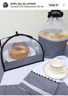 a table topped with two baskets filled with food next to a cup and saucer