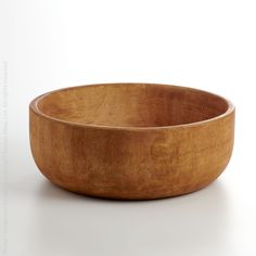 a wooden bowl sitting on top of a white table