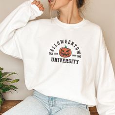 Custom Est Year Embroidered Halloween Town University Sweatshirt, Halloween Town Est 1998 Embroidered Sweatshirt, Retro Halloween Hoodie  Gildan Sweatshirt G18000 (Hoodie G18500) Details: - 8 oz., 50% usa cotton, 50% polyester - Heather sport colors: 60% polyester, 40% cotton - Made with 50% sustainably and fairly grown usa cotton - Pill-resistant air jet yarn - Double-needle stitching throughout - Double-lined hood(Hoodie) - Pouch pocket(Hoodie) - Matching drawcord - 1x1 ribbed cuffs and waistband with spandex Halloween College Sweatshirt In Cotton, Halloween College Cotton Sweatshirt, Halloween Cotton College Sweatshirt, Halloween Cotton Sweatshirt For College, Halloween Town University, Embroidered Halloween, University Sweatshirts, Halloween Hoodie, Sweatshirt Halloween