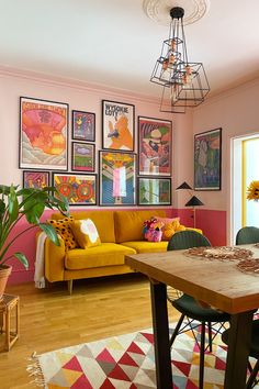 a living room filled with furniture and pictures on the wall above a wooden dining table