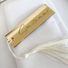 a gold nameplate with the word gazzane on it and a white thread