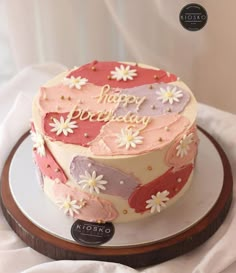 a birthday cake decorated with flowers and the words happy birthday on it's top