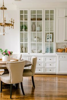 a dining room table with chairs and a chandelier in the backround