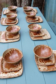 a blue table topped with lots of brown dishes