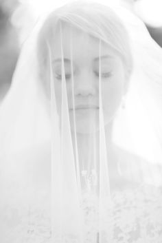 black and white photograph of a bride with veil over her face