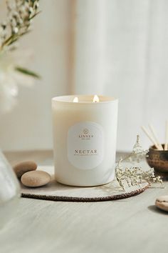 a white candle sitting on top of a wooden table