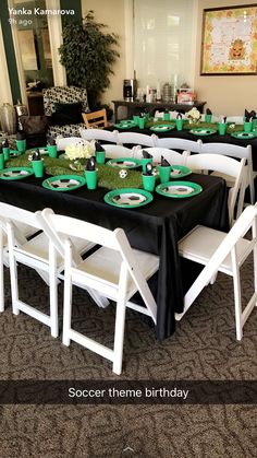 the table is set up with green and white plates, cups, and napkins