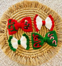 three knit bow ties sitting on top of a wicker basket next to candy canes