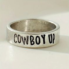 Elevate your style with the Cowboy Up Stamped Ring! This eye-catching piece will make a statement and add a touch of Western flair to your wardrobe. With its unique design, this ring is sure to turn heads and showcase your individuality. Add a touch of personality to your look and show off your love for all things Western with the Cowboy Up Stamped Ring! women’s size 7.5-8 ring Western Gift Ideas, Western Rings, Stamped Ring, Cowboy Up, The Cowboy, Christmas 2024, Ring Women, Stamped Jewelry, Makeup Case