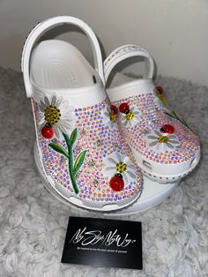 MyStyleMyWay's  custom crocs are designed for the perfect outfit, that special occasion, and "Just Because" you love blinged out crocs.  In the display shown we designed a pair of white classic crocs adding high quality colorful rhinestones. 🐞Each Rhinestone is individually and neatly placed to achieve the design.  🌼 Rhinestones are added to the top and buttom trimming of the shoe.  🐞 Personality Patch is applied to this design to add cuteness and personality.  🌼 Personalization on this design can be achieved upon request.  🐞 The sports mode strap is also designed.   🌼 When making your purchase - You're making a purchase for the exact style shown. If you would like a different color rhinestone,  and or different charms please message us so we can assist you. We're committed to the un Painted Crocs Ideas, Fun White Clogs For Spring, White Fun Spring Clogs, Blinged Out Crocs, Bedazzled Crocs, Daisy Patches, Custom Crocs, Classic Crocs, Bling Design