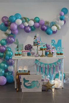 an under the sea themed party with balloons and mermaid cake, cupcakes and decorations