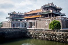 an old chinese building next to a body of water