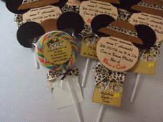 there are many mickey mouse lollipops on the table with tags attached to them