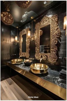 a bathroom with two sinks and mirrors in the center, gold bowls on the counter