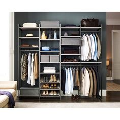 an organized closet with clothes, shoes and bags on shelves next to a couch in a living room