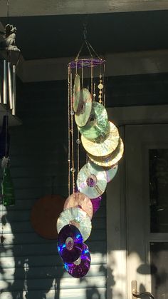 a wind chime hanging from the side of a house with lots of discs attached to it