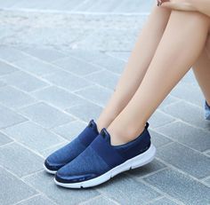 a woman is sitting on the ground with her legs crossed and wearing blue slippers