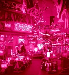 a room filled with lots of neon signs and lights on the walls, all lit up in pink