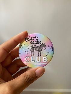 a person holding up a badge that says ehler's dappos club