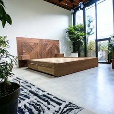 a bed sitting on top of a white floor next to a plant