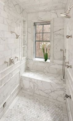 a white marble bathroom with window and shower