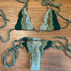 three pieces of crocheted clothing on a wooden table