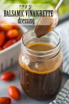 a spoon full of balsamic vinaigrete dressing with tomatoes in the background