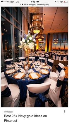 a table set up with blue and white linens for a formal function in front of a large window