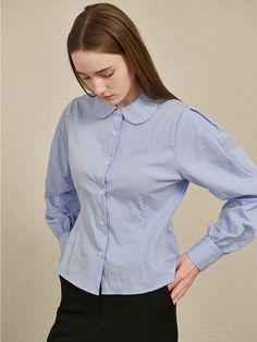 This round collar cotton shirt by Nouve combines a refined silhouette with sophistication, exuding modern mood.- Made with high-density bio-cotton fabric for a soft touch and minimal wrinkles- Features puff sleeves and a round collar for charming details- Slim waistline achieved with dart design* Threads and wrinkles that occur during the production process, as well as chalk marks, are not considered defects.* Actual product color may vary according to the monitor resolution. Cotton Puff Sleeve Shirt For Work, Cotton Puff Sleeve Shirt For Office, Office Puff Sleeve Cotton Shirt, Classic Shirt With Puff Sleeves In Relaxed Fit, Classic Puff Sleeve Shirt With Relaxed Fit, Solid Cotton Puff Sleeve Shirt, Solid Cotton Tops For Office Wear, Cotton Top For Office Wear, Collar Shirt For Women